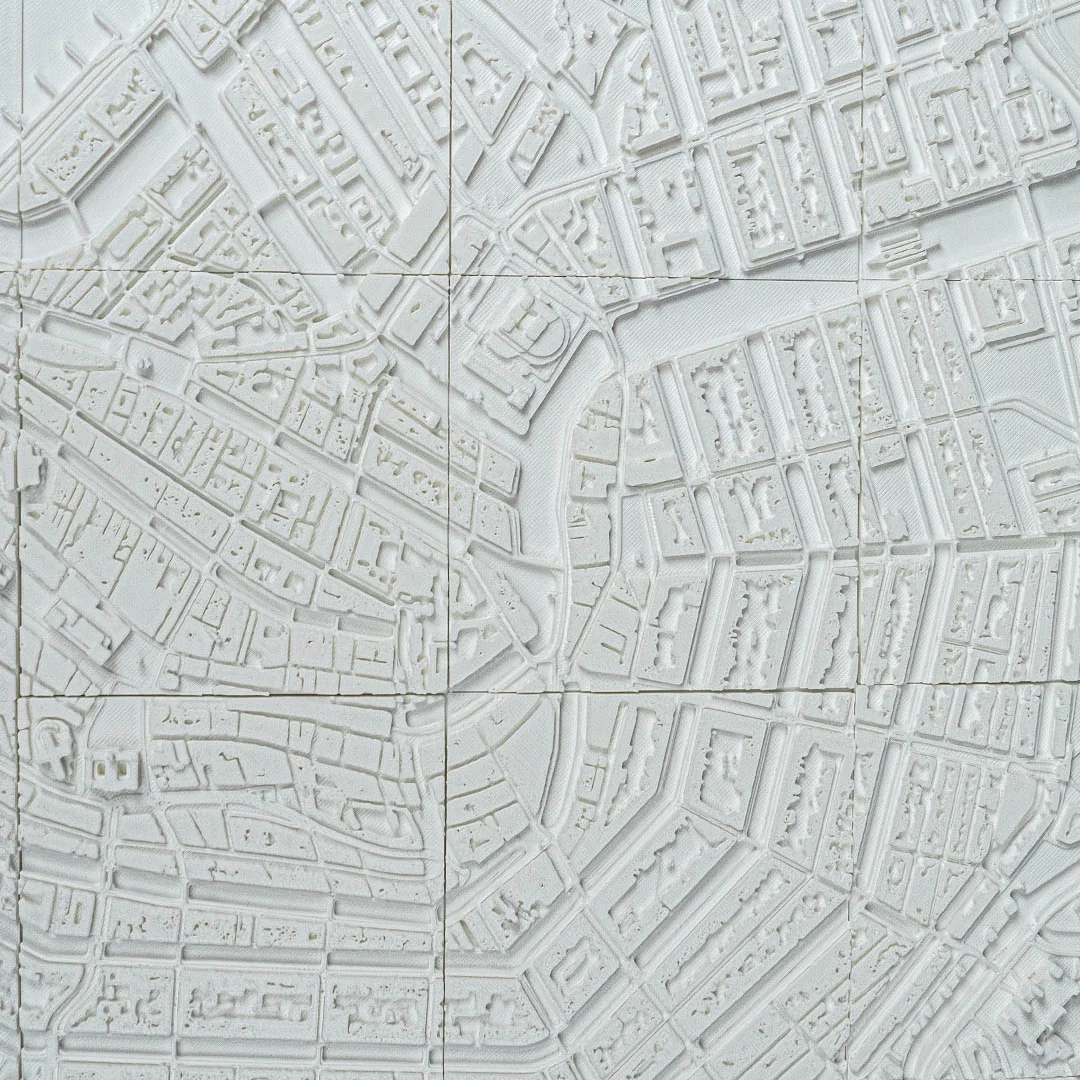 Overhead detail of an Amsterdam city map showing canals and neighbourhood blocks.