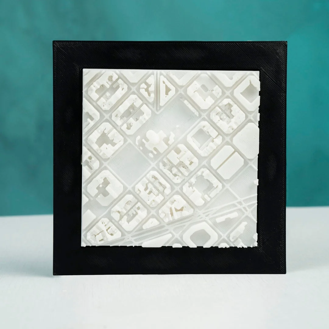 Framed Barcelona city relief map showing the geometric street grid.