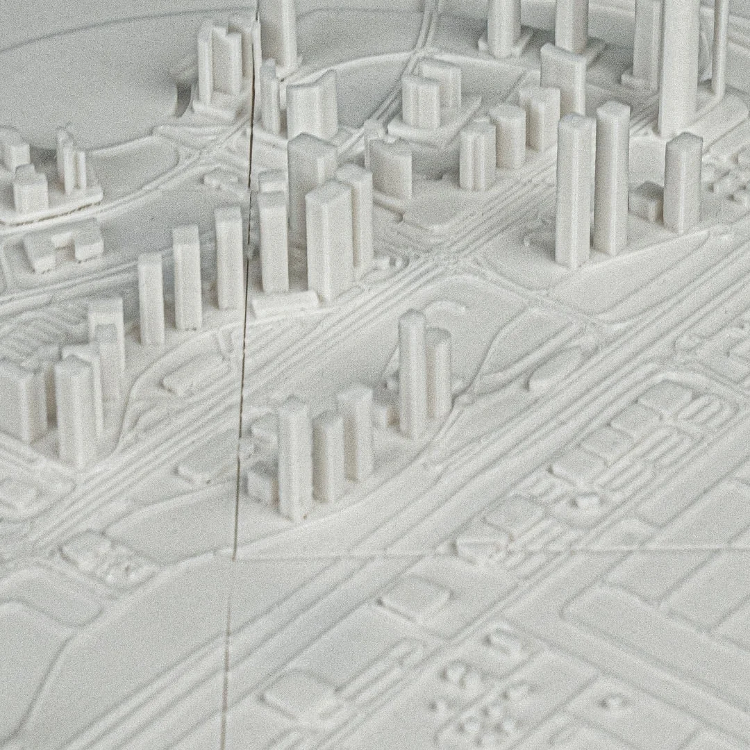 Angled detail of raised buildings and roads in a Dubai city relief map.