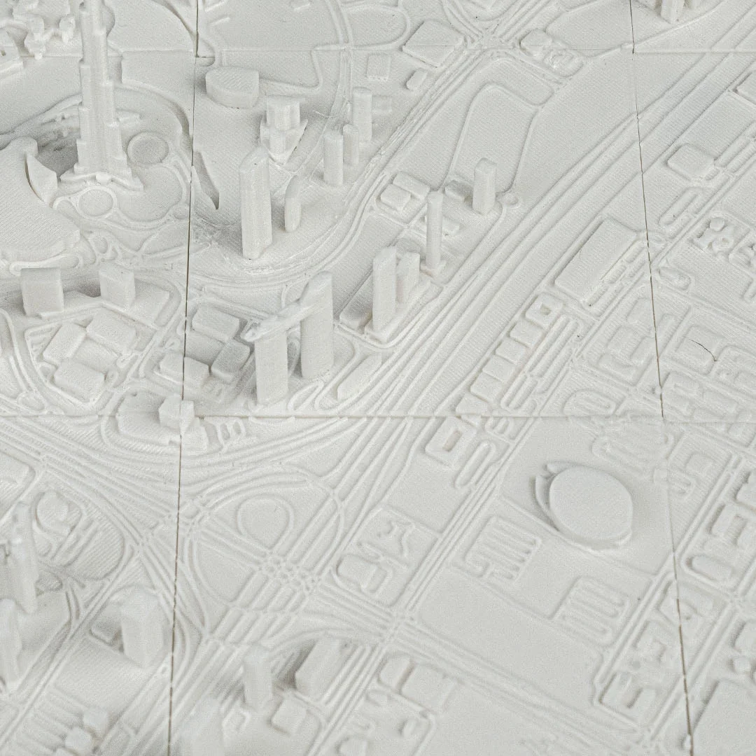 Overhead detail of roads and building blocks in a Dubai city relief map.