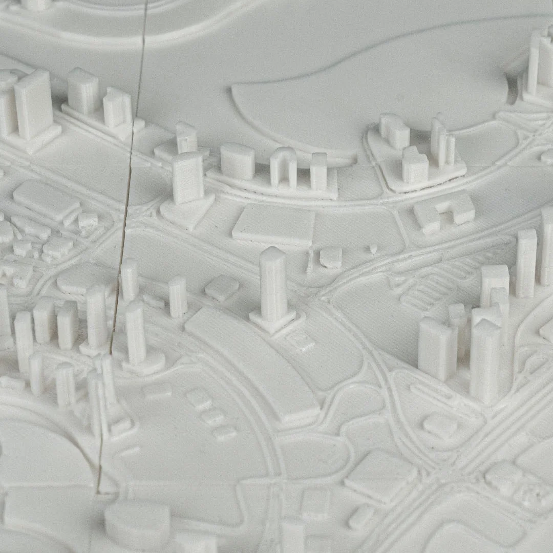 Close overhead view of curved roads and waterfront buildings in a Dubai relief map.