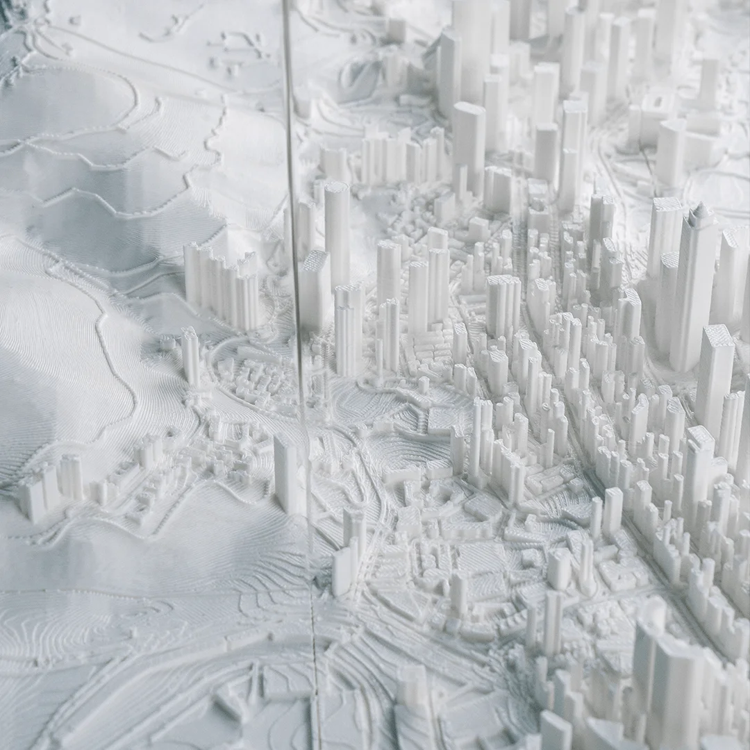 Overhead detail of hillside contours and buildings in a Hong Kong city relief map.
