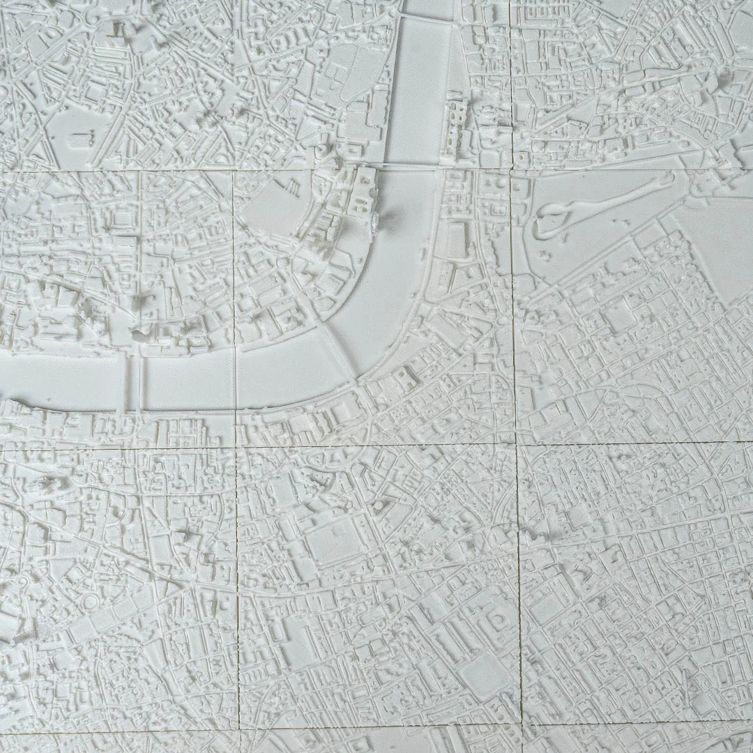 Overhead detail of a London city relief map showing a river bend and bridges.