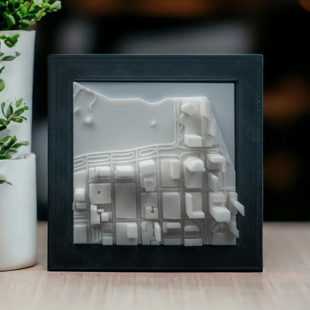 Framed Miami city relief map displayed upright, showing waterfront buildings.