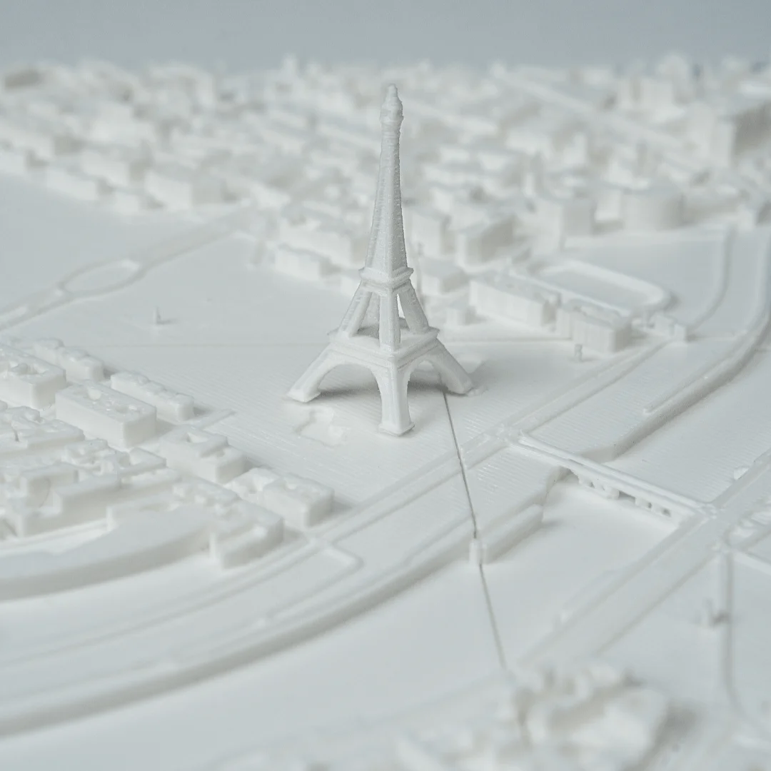Angled view of the Eiffel Tower and nearby river in a Paris relief map.