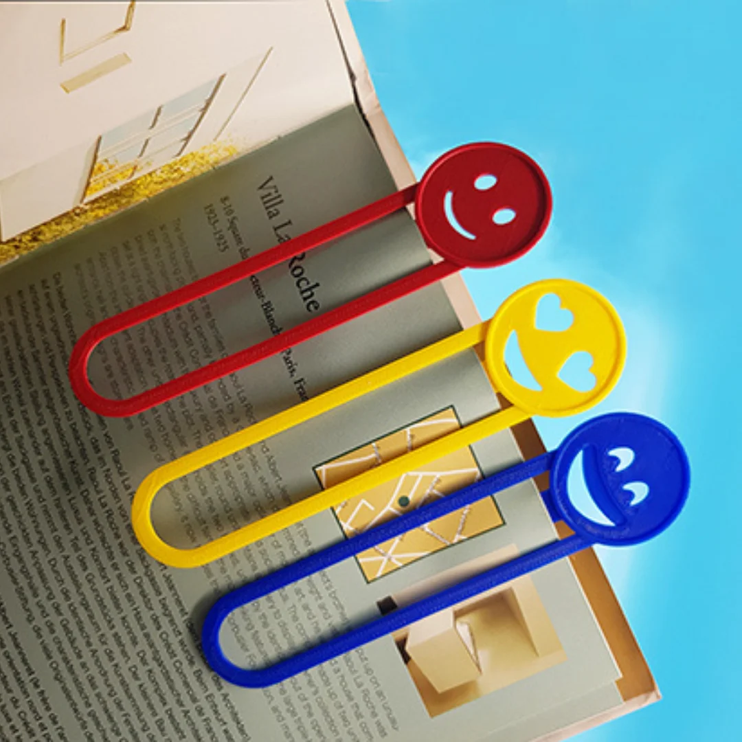 Emoji bookmarks clipped onto pages of an open book.