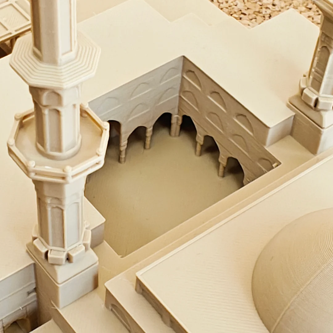Close view of a King Faisal Mosque model showing the minaret base and courtyard arches.