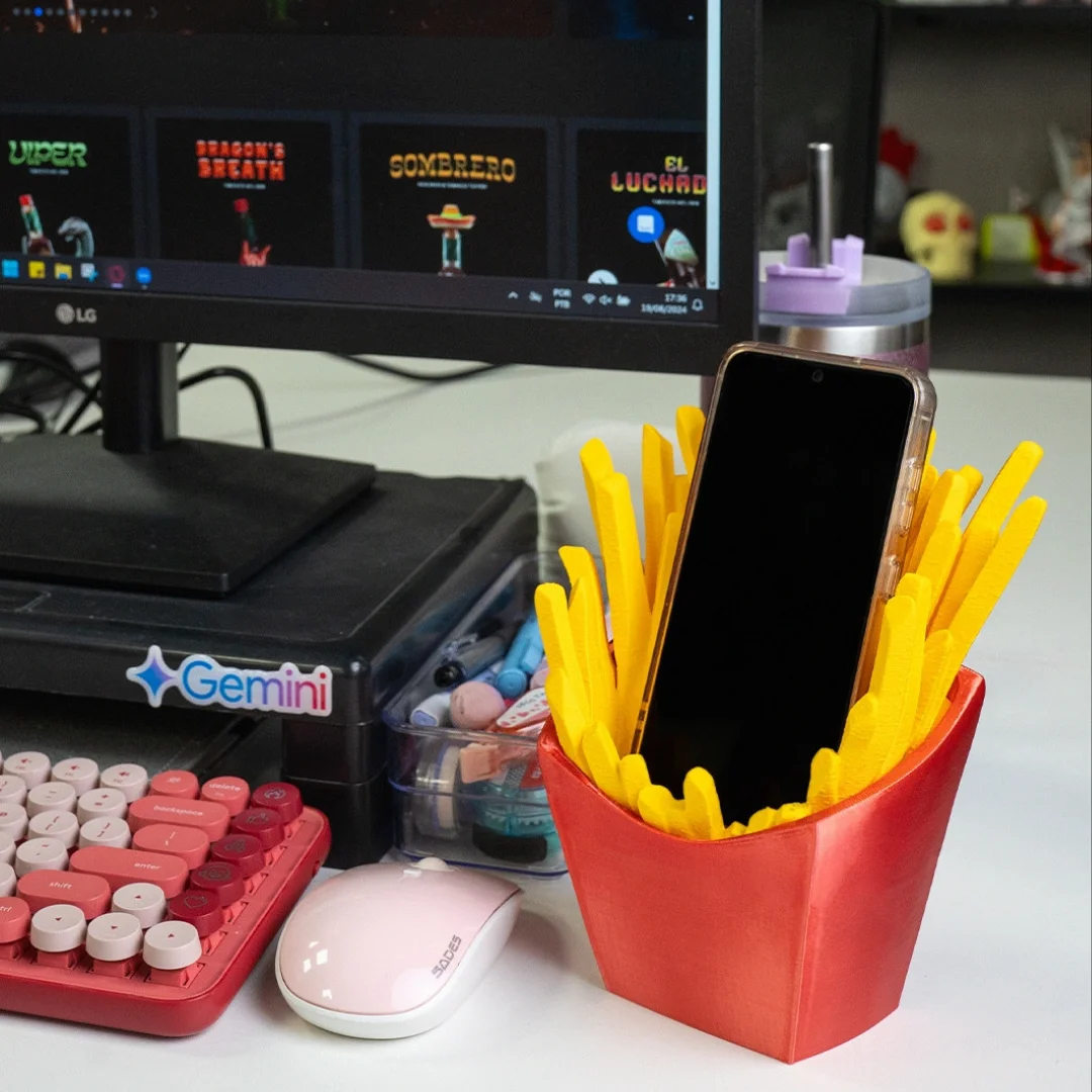 French fries phone holder with a smartphone displayed on a desk.