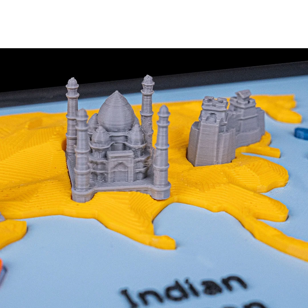 Close view of miniature buildings on the Asia section of a world map model.