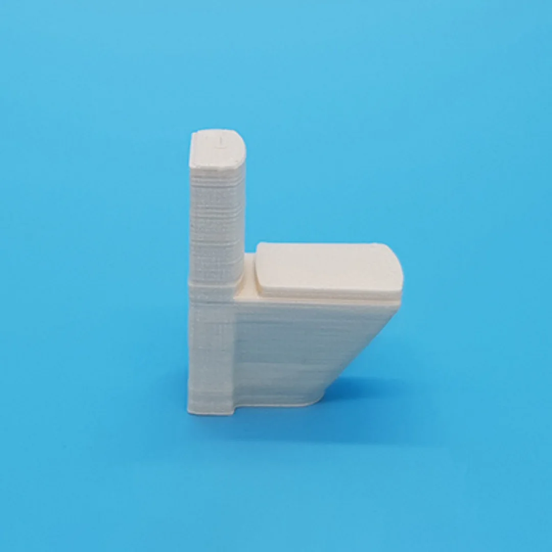 Modern toilet miniature model viewed from the side at 1:50 scale.