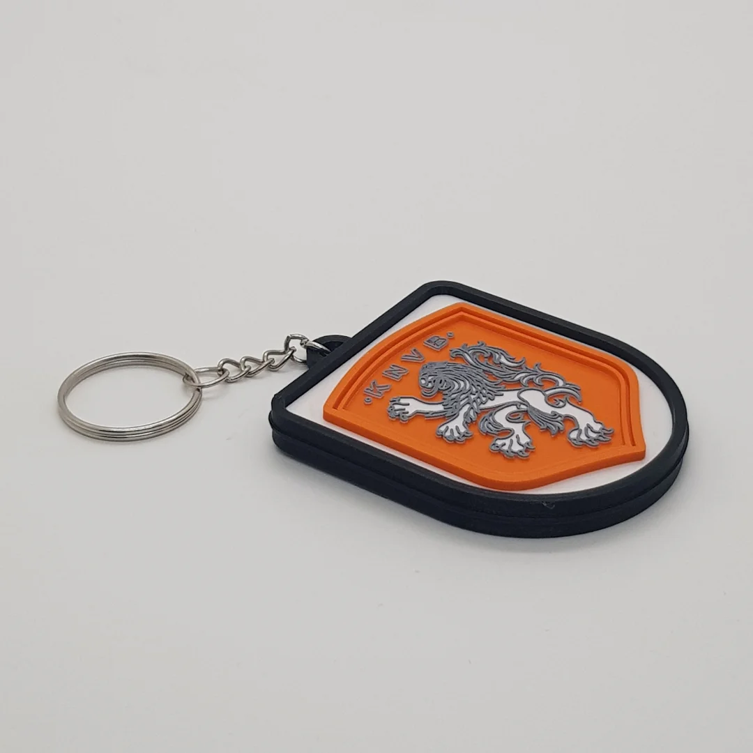 Angled front view of a Netherlands football keychain showing the raised crest and metal key ring.