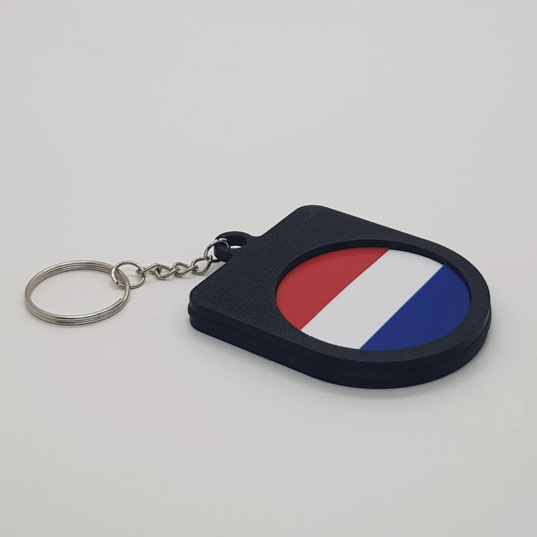 Angled rear view of a Netherlands football keychain showing the national flag inset.