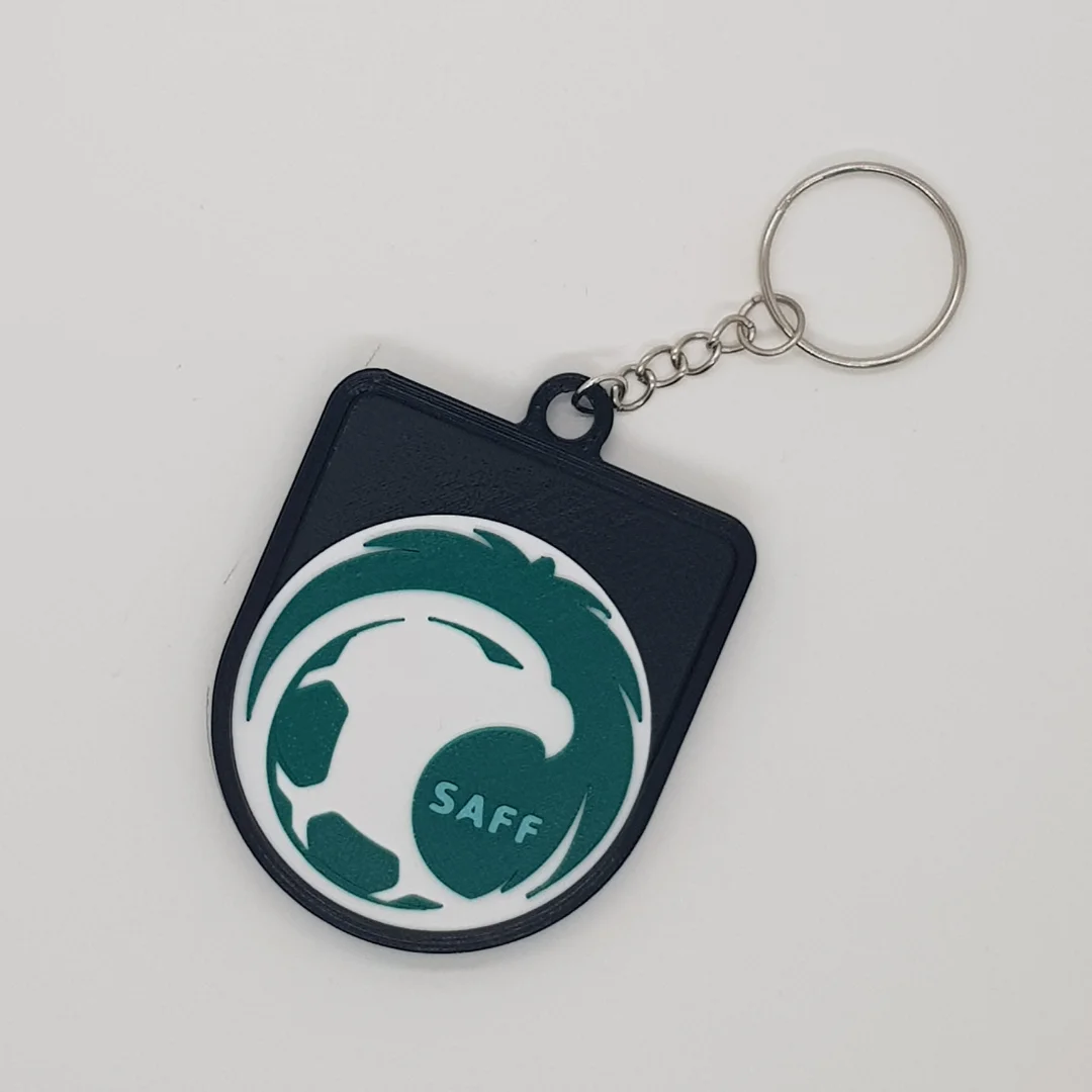 Front view of a Saudi Arabia football crest keychain with its chain and key ring.