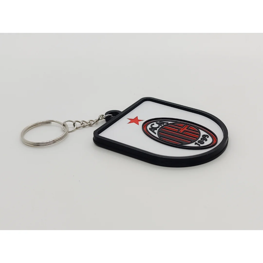 Angled view of the AC Milan keychain showing the club crest and metal key ring.