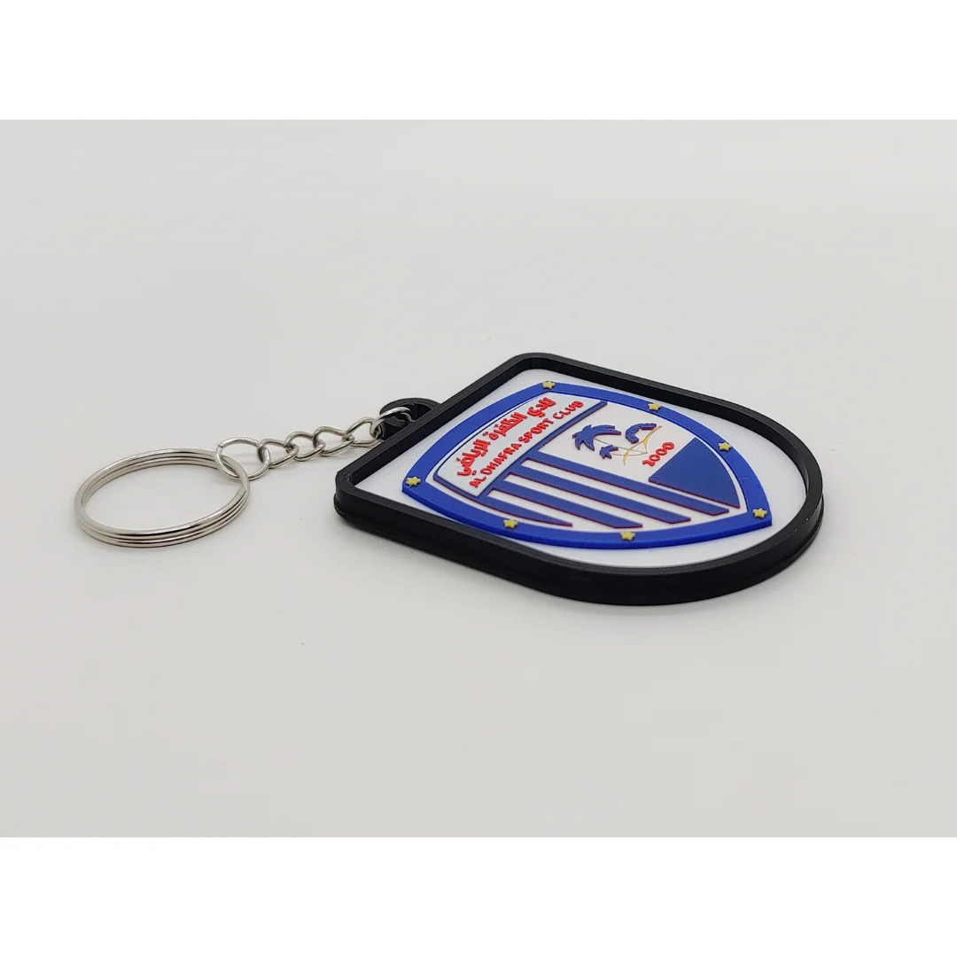Angled view of the Al Dhafra FC keychain showing the club crest and metal key ring.