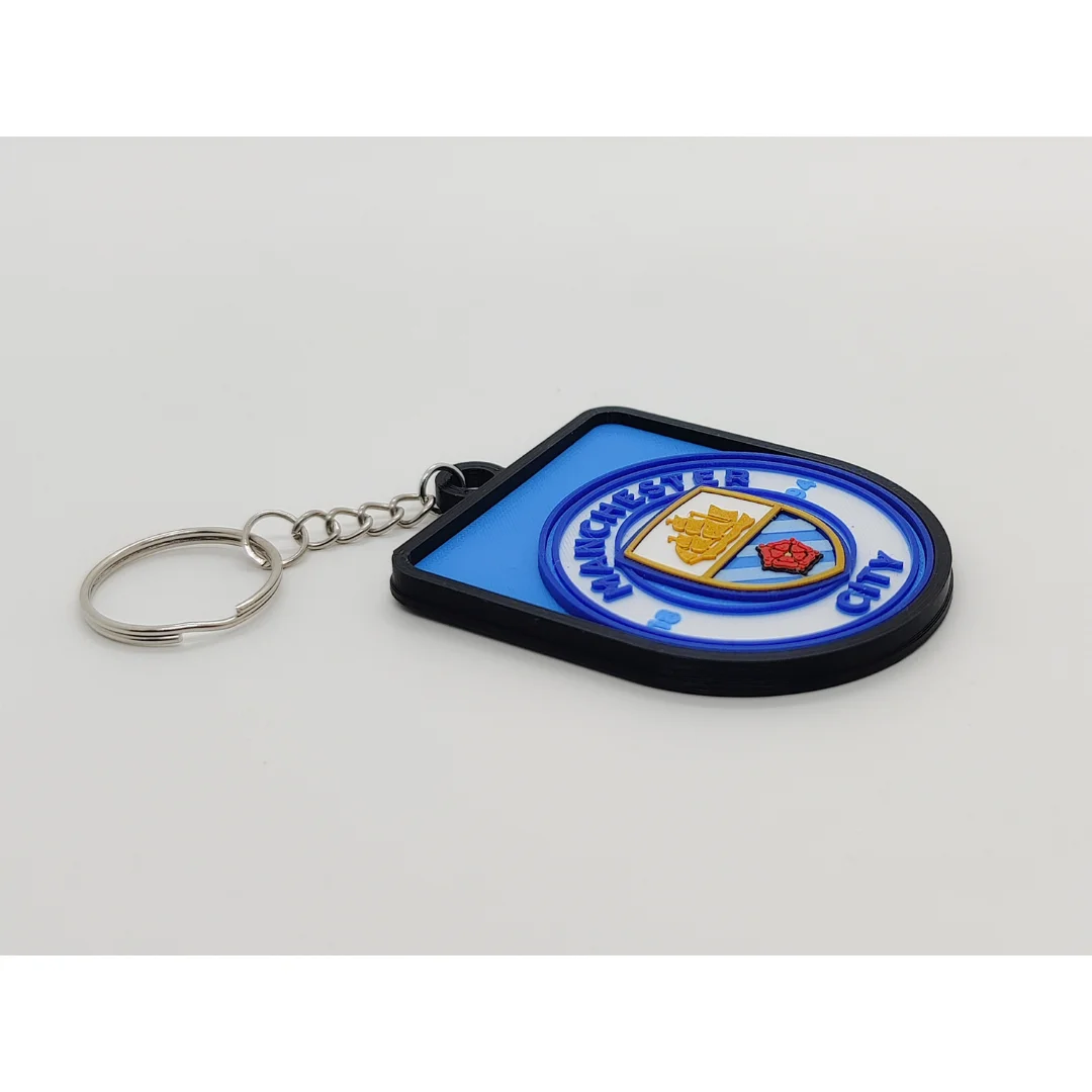 Angled view of the Manchester City FC keychain showing the club crest and metal key ring.