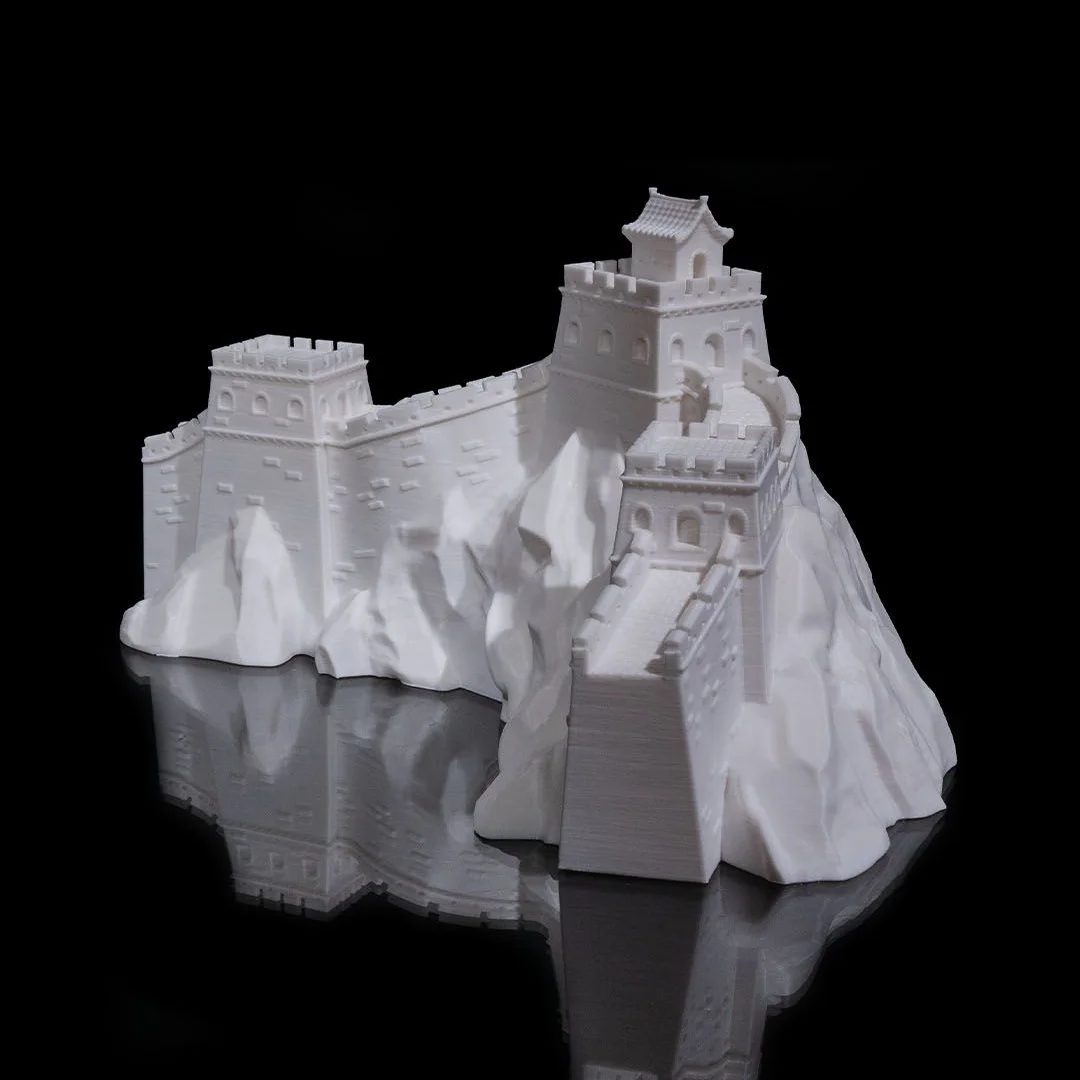 Great Wall of China model with watchtowers and stairs on a mountain-shaped base.