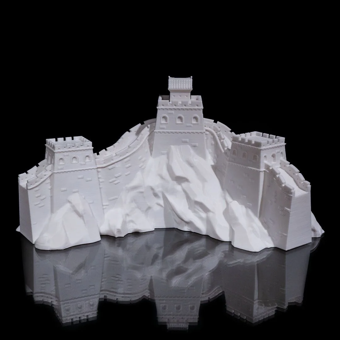 Front view of a Great Wall of China model showing towers and sloping walls.