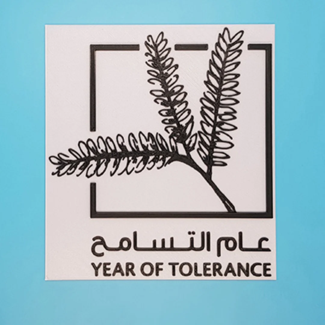 Front view of a Year of Tolerance plaque with branch design in a square outline.